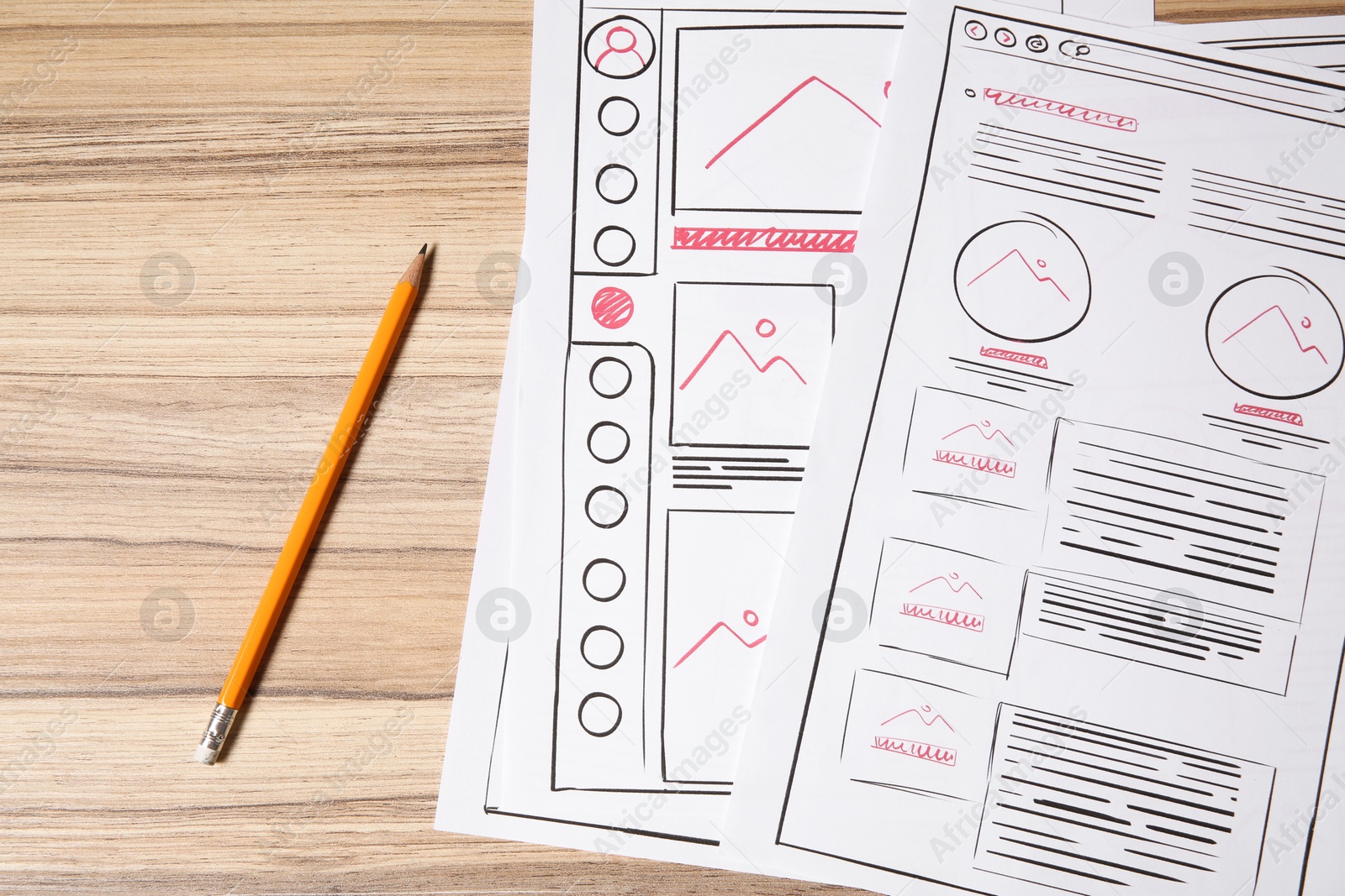 Photo of Website development. Sketches of wireframes and pencil on wooden table, flat lay