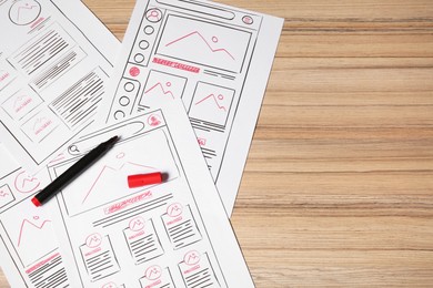 Photo of Website development. Sketches of wireframes and felt pen on wooden table, flat lay. Space for text