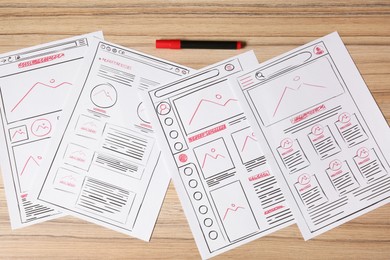 Website development. Sketches of wireframes and felt pen on wooden table, flat lay