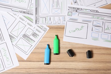 Photo of Website development. Sketches of wireframes and highlighters on wooden table, flat lay