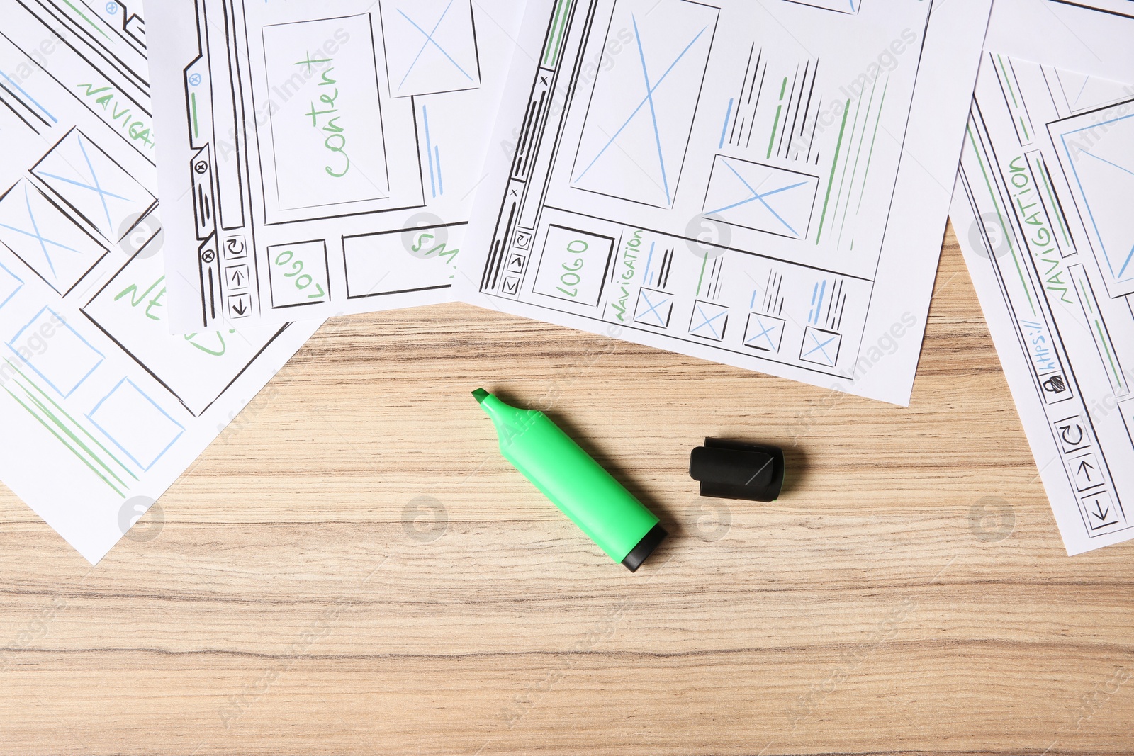 Photo of Website development. Sketches of wireframes, and highlighter on wooden table, flat lay