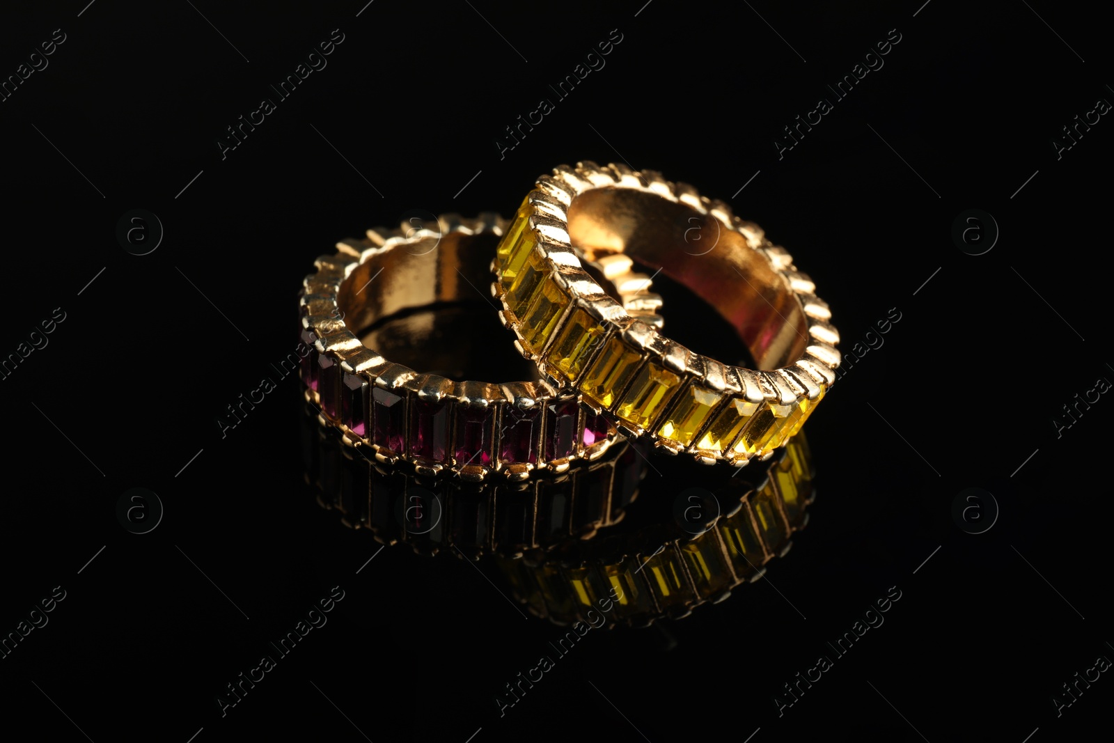 Photo of Beautiful bijouterie. Stylish rings on black background