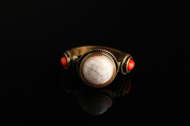 Photo of Beautiful bijouterie. Stylish ring on black background