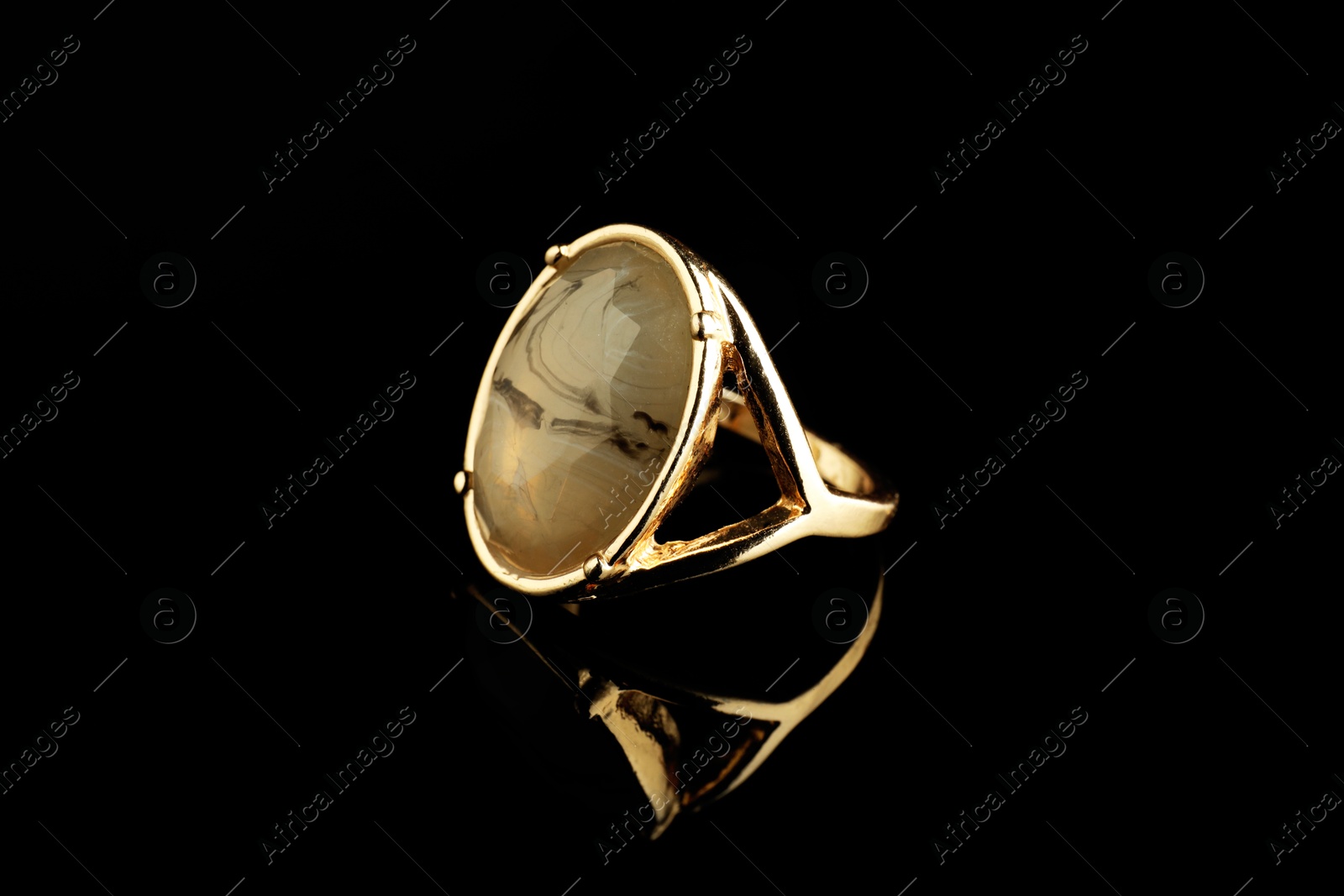 Photo of Beautiful bijouterie. Stylish ring on black background