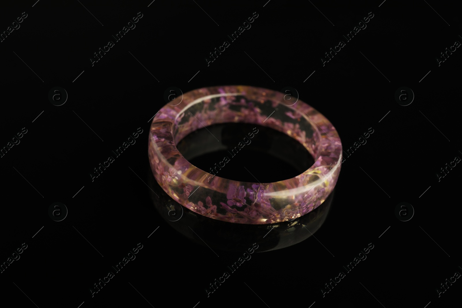 Photo of Beautiful bijouterie. Stylish ring on black background