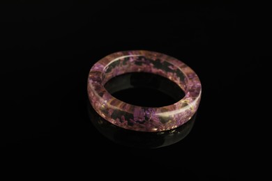 Photo of Beautiful bijouterie. Stylish ring on black background