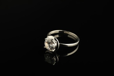 Photo of Beautiful bijouterie. Stylish ring on black background