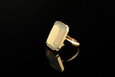 Photo of Beautiful bijouterie. Stylish ring on black background