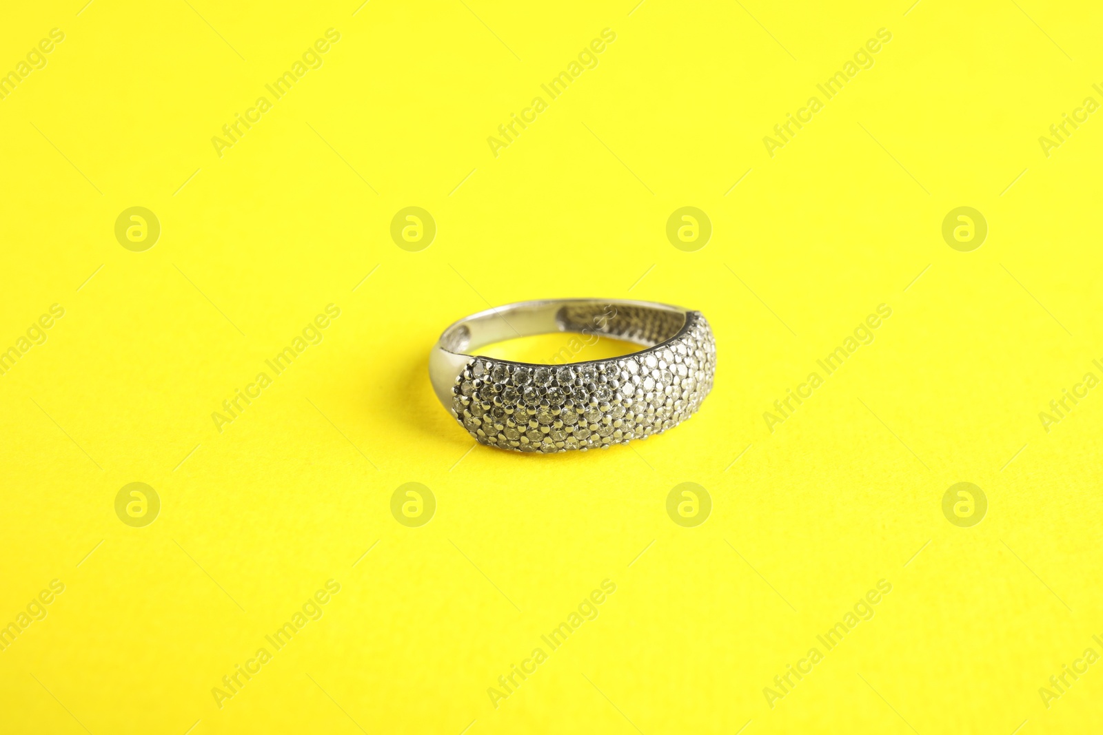 Photo of Beautiful bijouterie. Elegant ring on yellow background