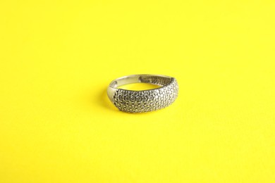 Photo of Beautiful bijouterie. Elegant ring on yellow background