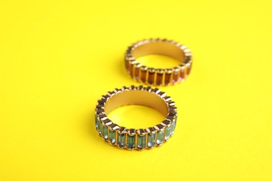 Photo of Beautiful bijouterie. Stylish rings on yellow background