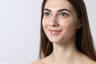 Beautiful young woman after henna eyebrows dyeing on light background