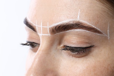 Photo of Young woman during henna eyebrows dyeing procedure on white background, closeup