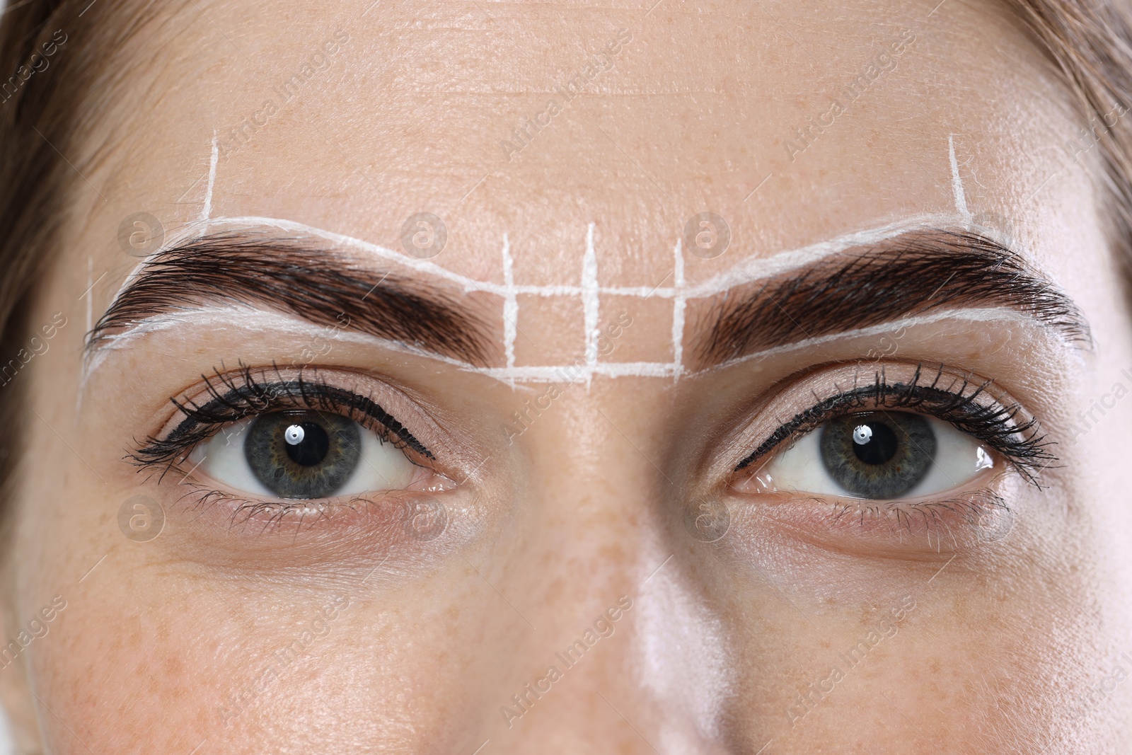 Photo of Young woman during henna eyebrows dyeing procedure, closeup