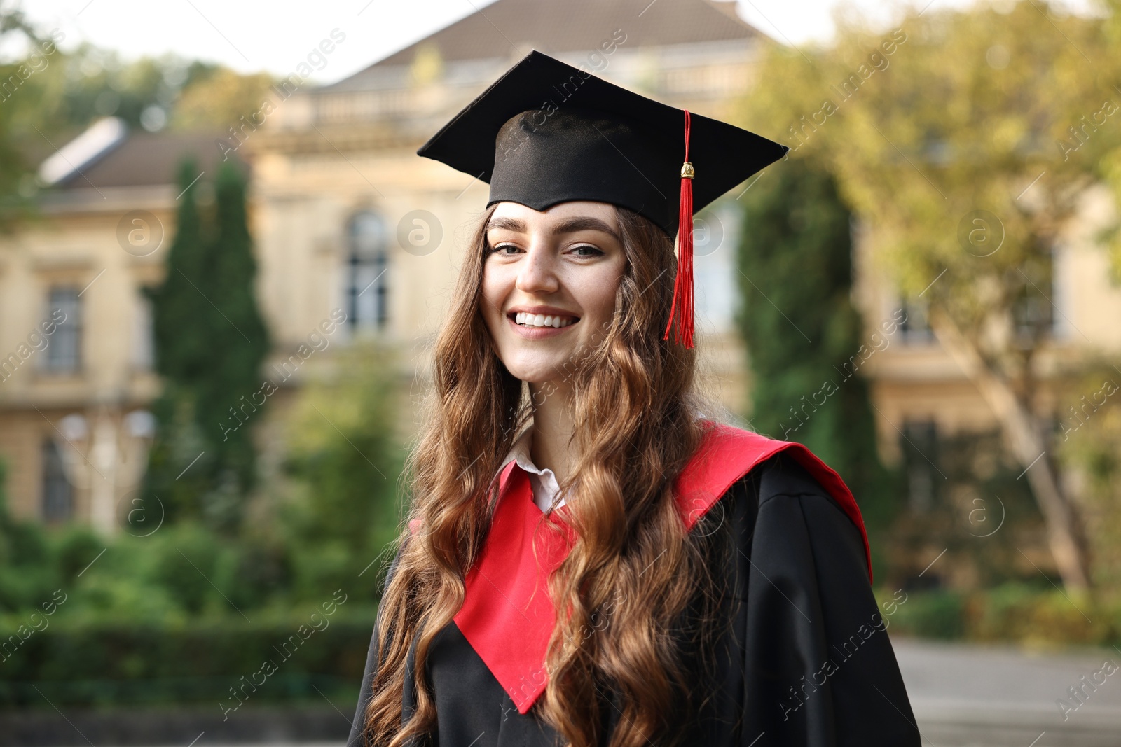 Photo of Graduation ceremony. Happy student in academic dress outdoors