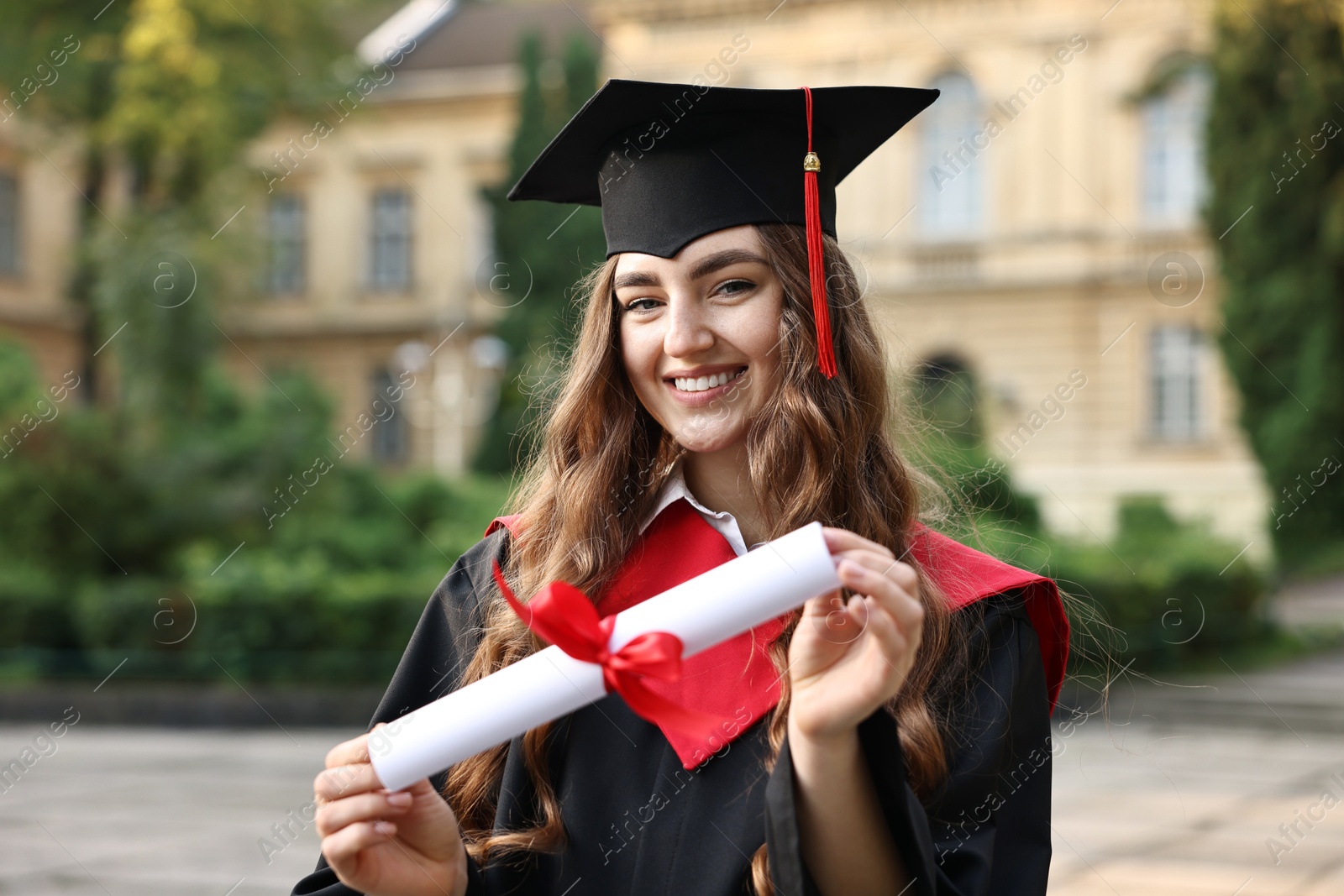 Photo of Happy student with diploma after graduation ceremony outdoors