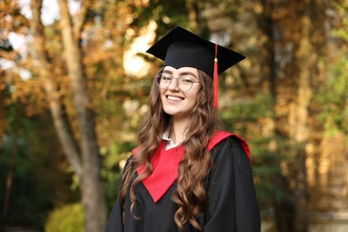 Photo of Graduation ceremony. Happy student in academic dress outdoors