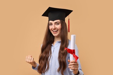 Photo of Happy student with diploma after graduation on beige background