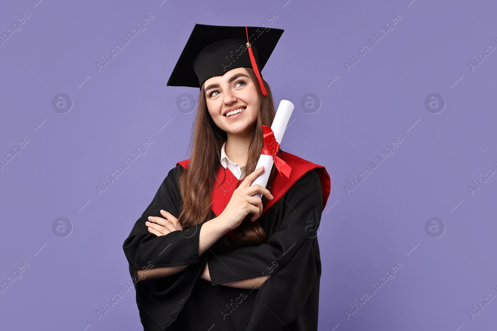 Photo of Happy student with diploma after graduation on violet background