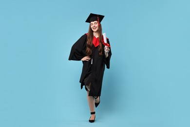 Photo of Happy student with diploma after graduation on light blue background