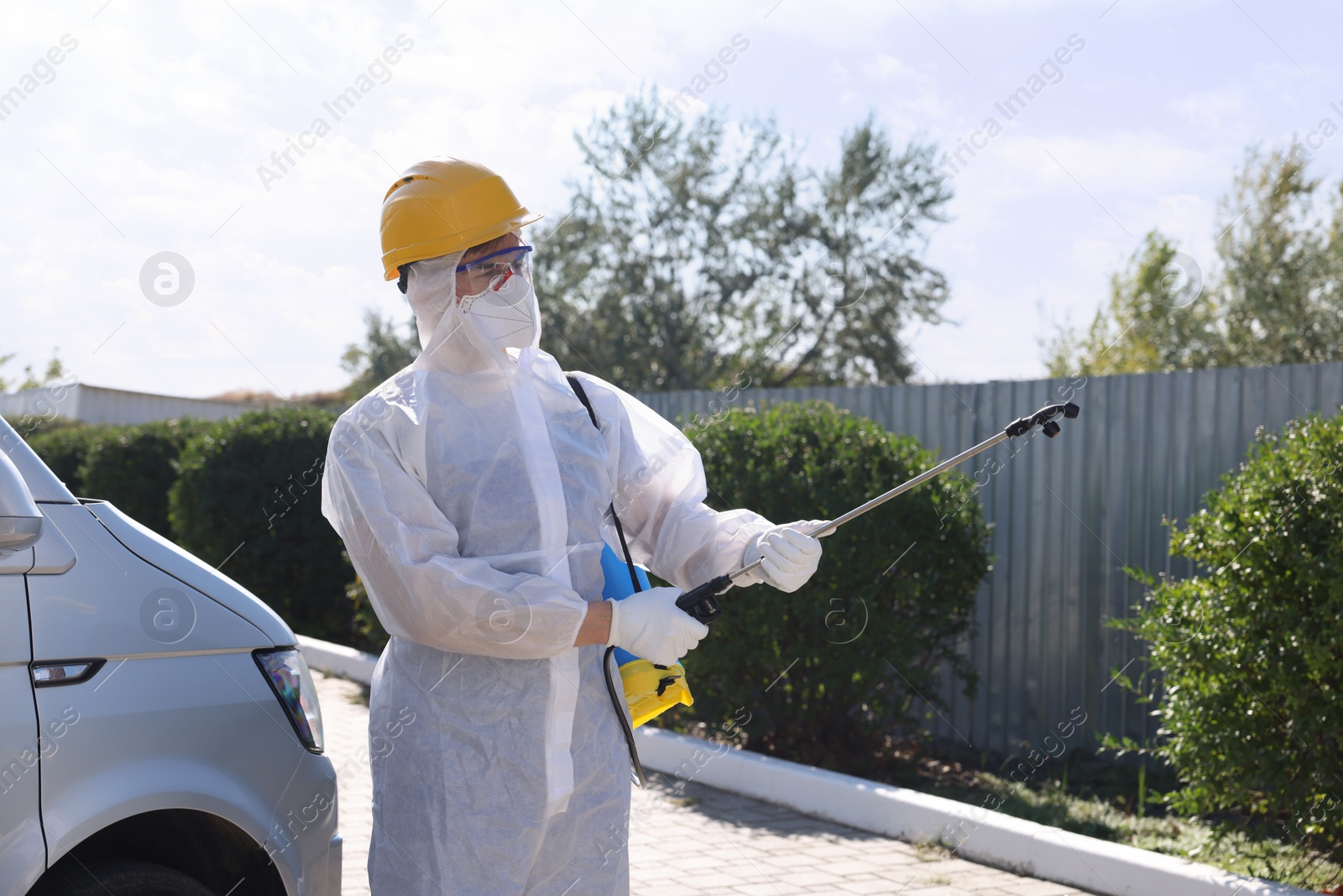 Photo of Pest control worker with spray tank outdoors