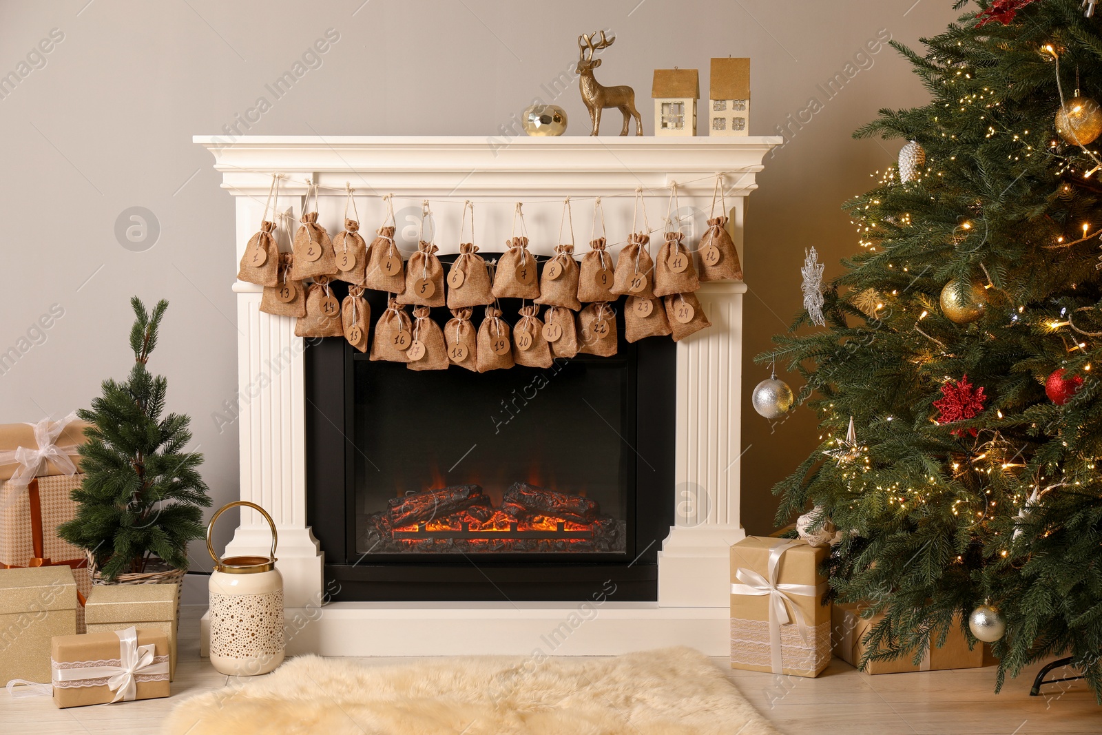 Photo of Advent calendar with gifts and decor hanging on fireplace Christmas near tree indoors