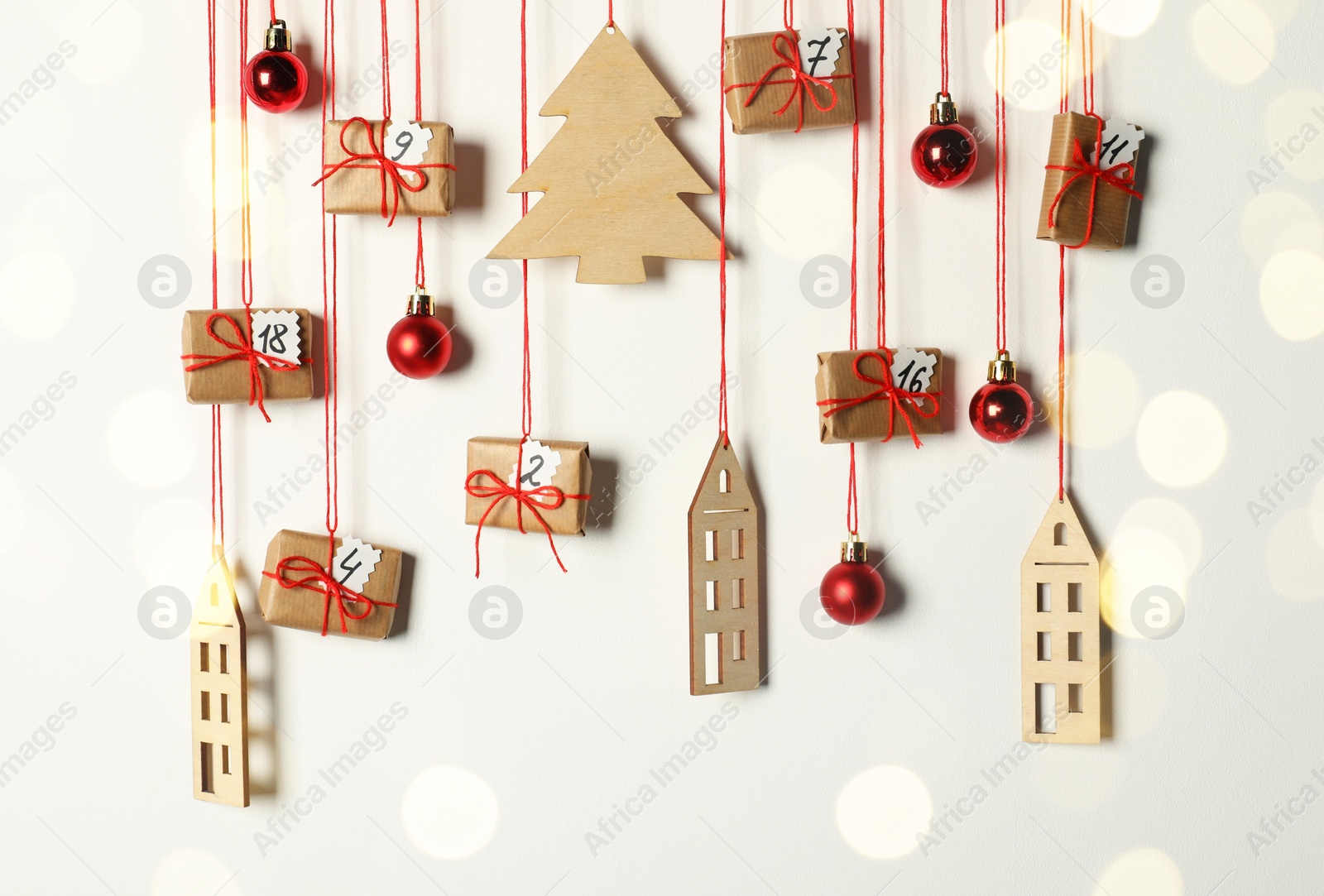 Photo of Handmade advent calendar with decor hanging on white background. Christmas tradition