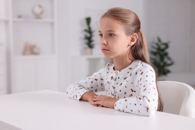 Photo of Girl with correct posture sitting at white desk indoors