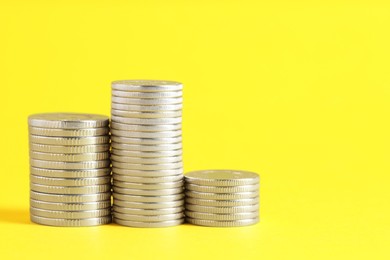 Photo of Salary concept. Stacked coins on yellow background, space for text