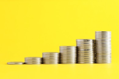 Photo of Salary concept. Stacked coins on yellow background, space for text