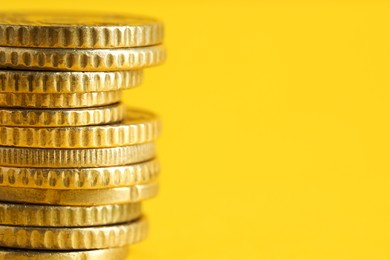 Photo of Salary concept. Stacked coins on yellow background, closeup. Space for text