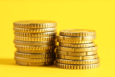 Photo of Salary concept. Stacked coins on yellow background, closeup