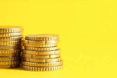 Photo of Salary concept. Stacked coins on yellow background, closeup. Space for text