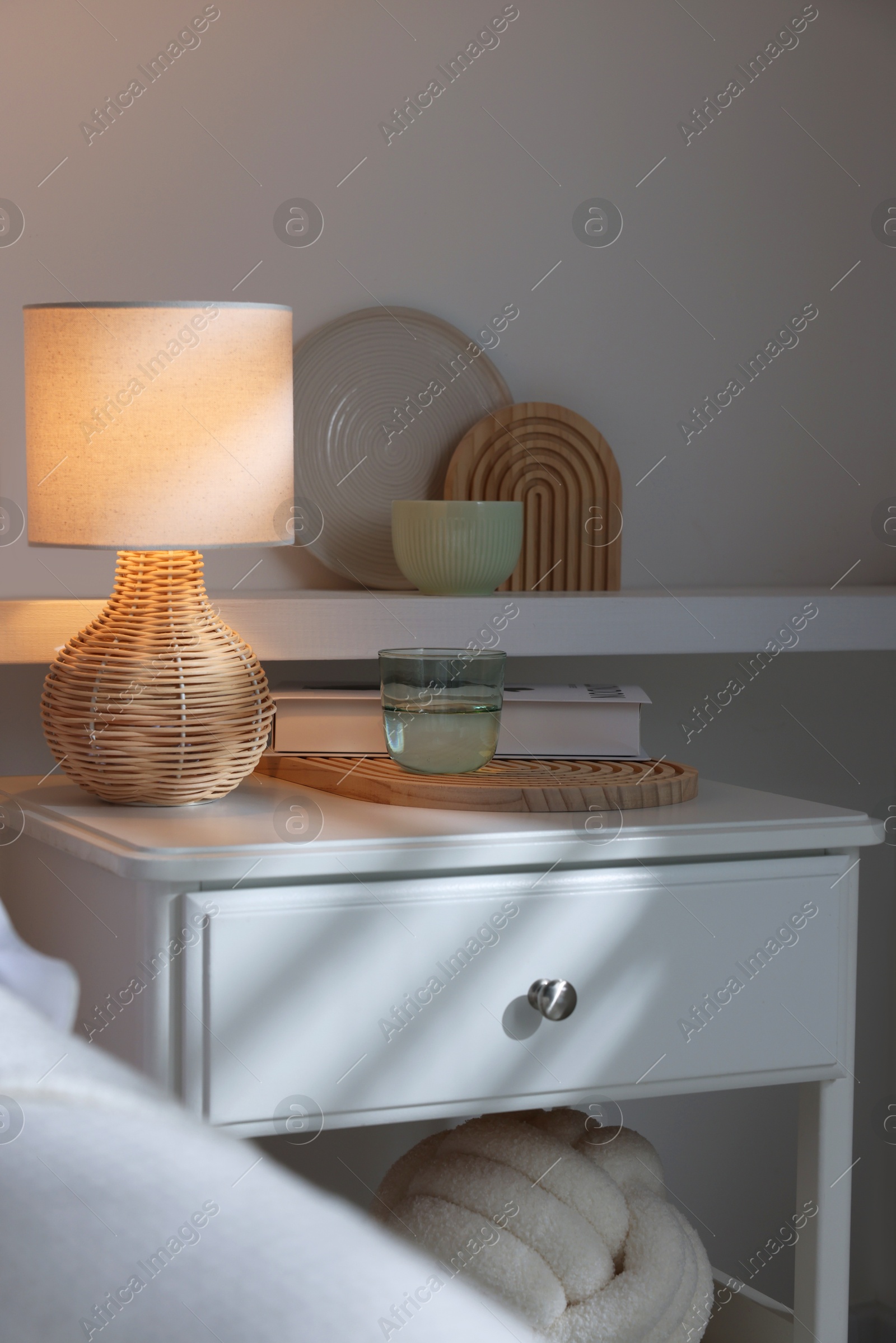 Photo of Stylish living room interior with bed, bedside table and lamp