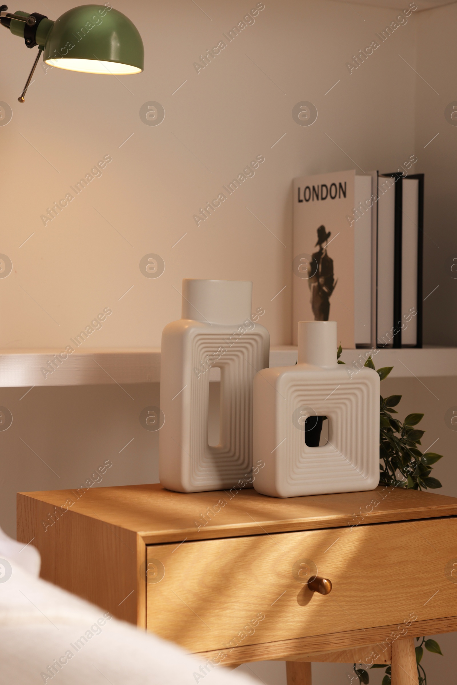 Photo of Beautiful vases on bedside table in room