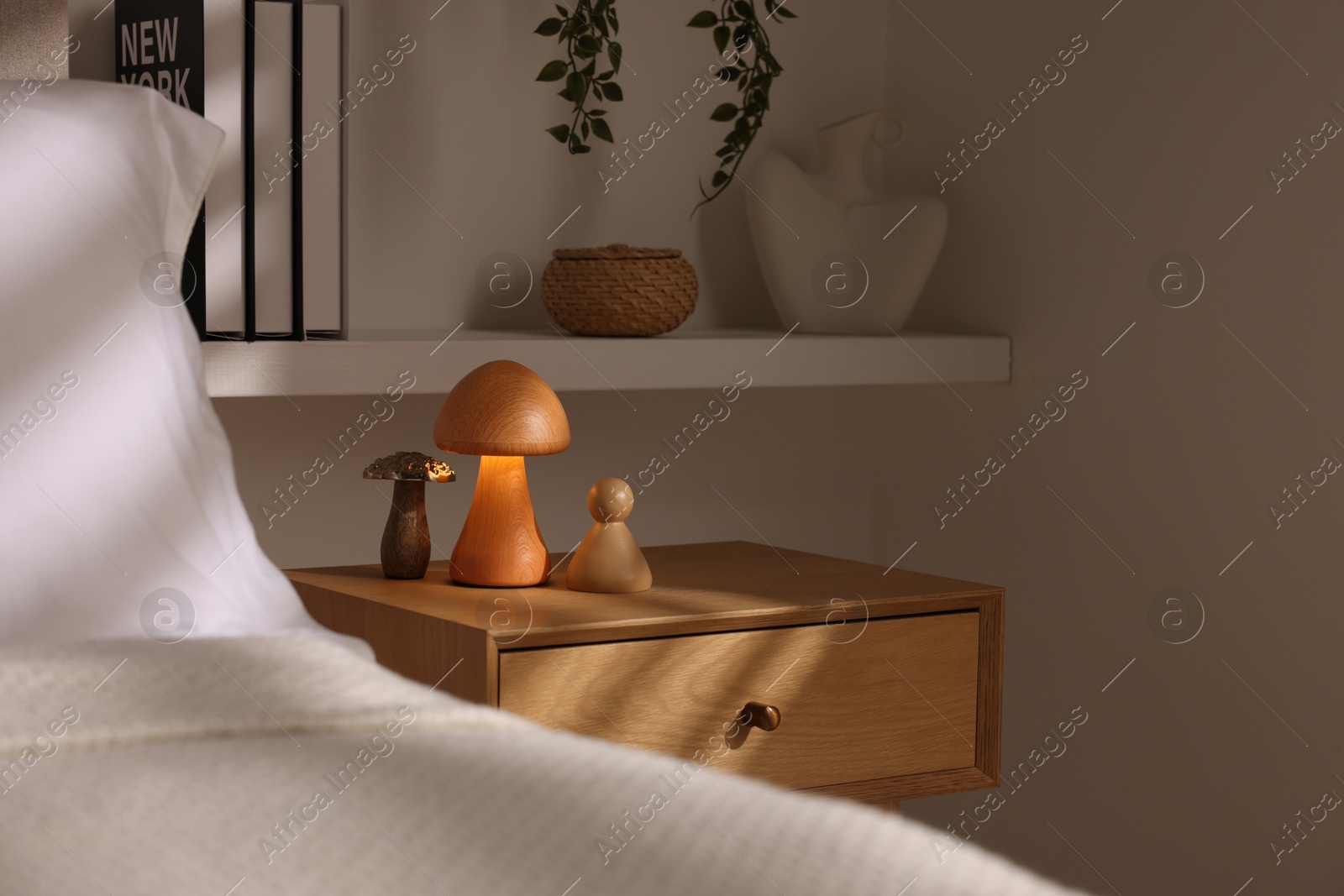 Photo of Stylish living room interior with bed, bedside table and night light