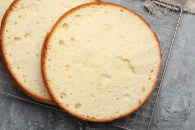 Photo of Delicious cut sponge cake on grey textured table, flat lay