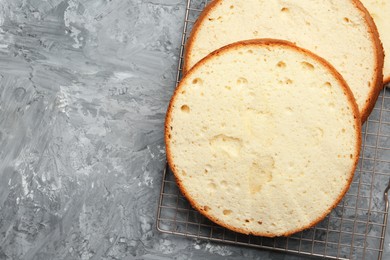 Photo of Delicious cut sponge cake on grey textured table, flat lay. Space for text