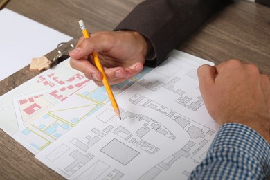 Photo of Real estate agent working with client at wooden table, closeup