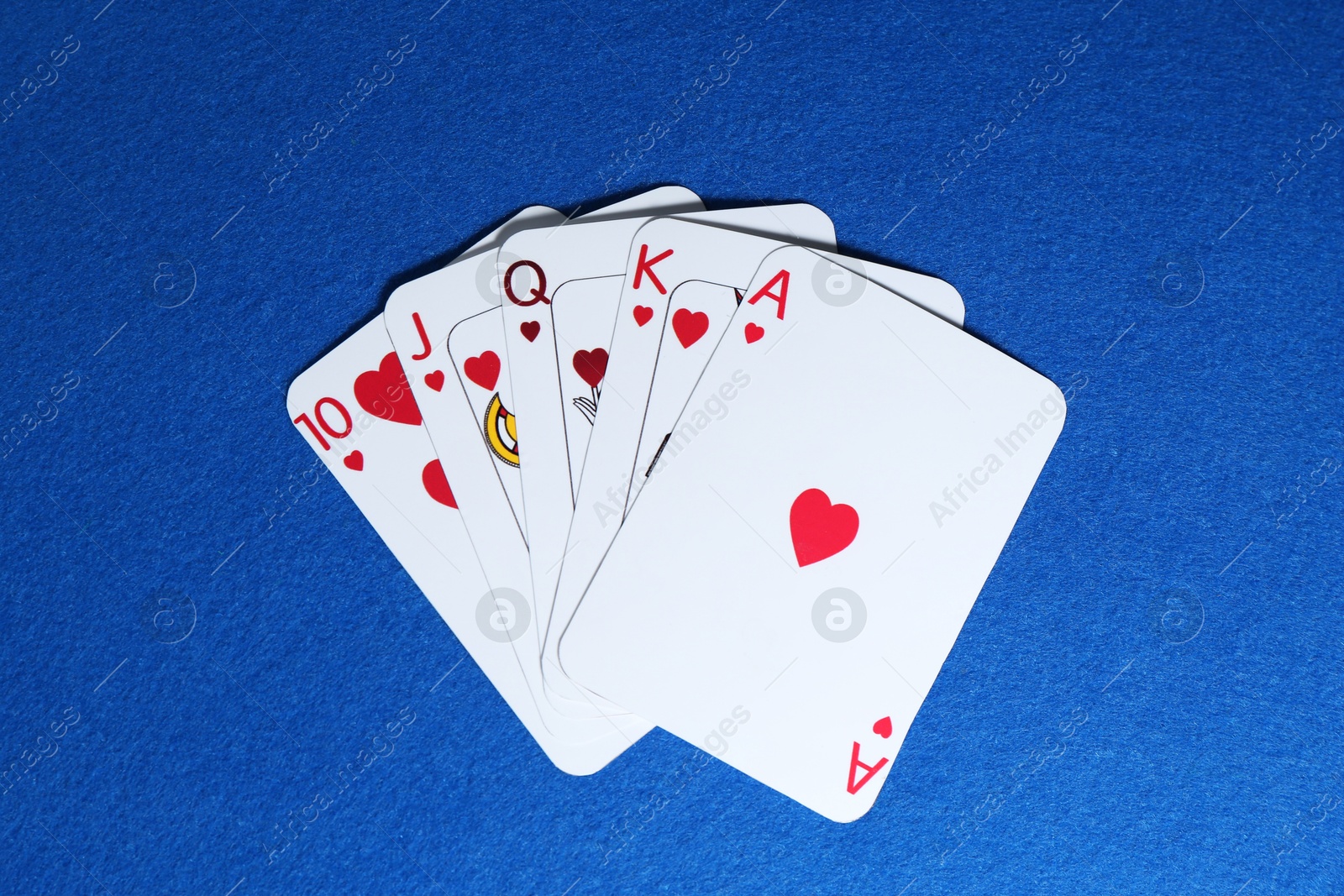 Photo of Poker game. Playing cards on blue table, top view