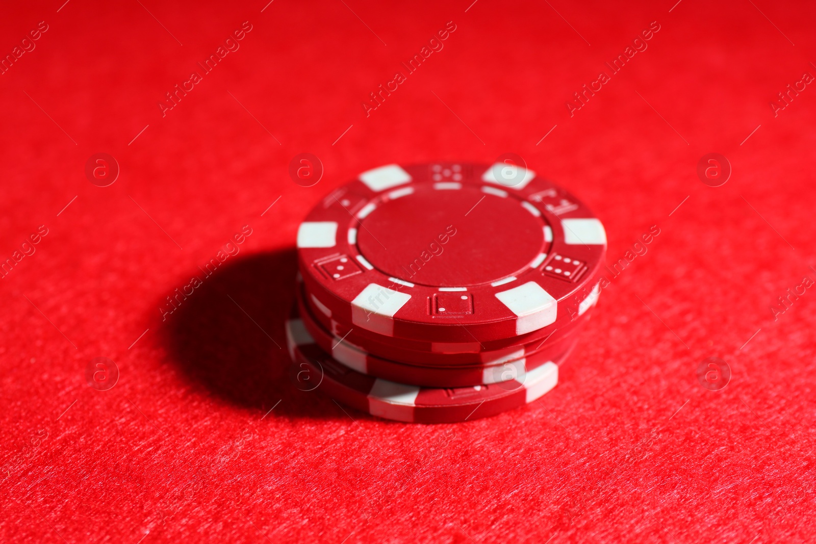 Photo of Poker game. Casino chips on red table