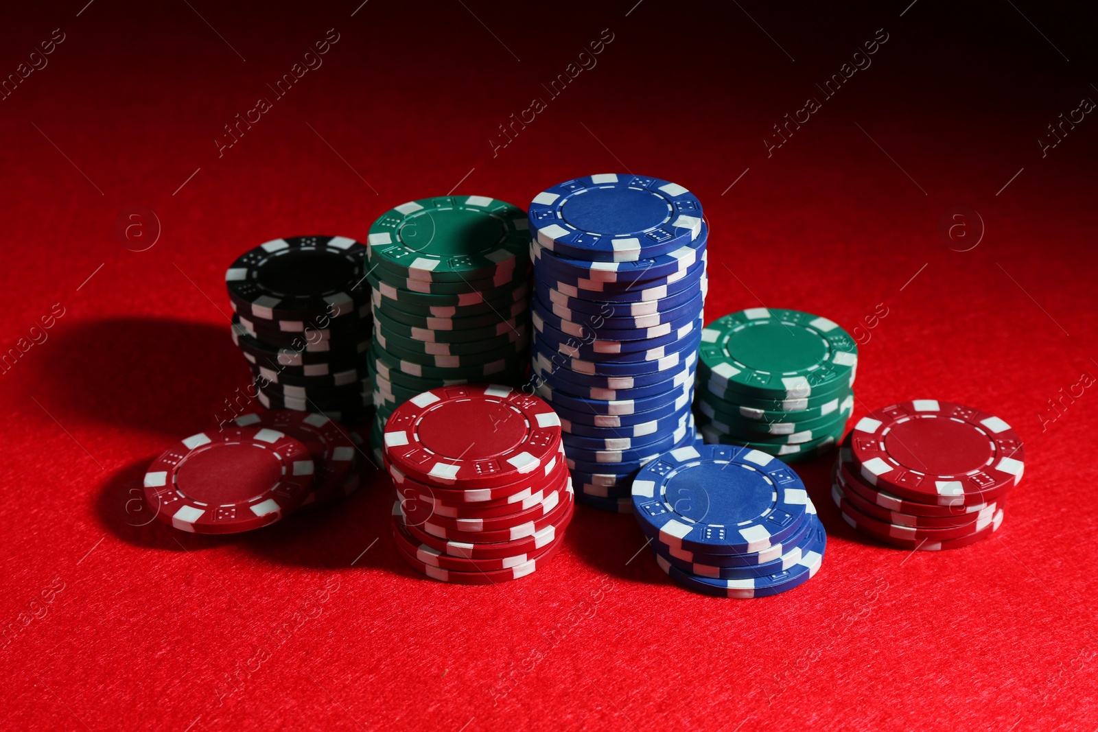 Photo of Poker game. Casino chips on red table