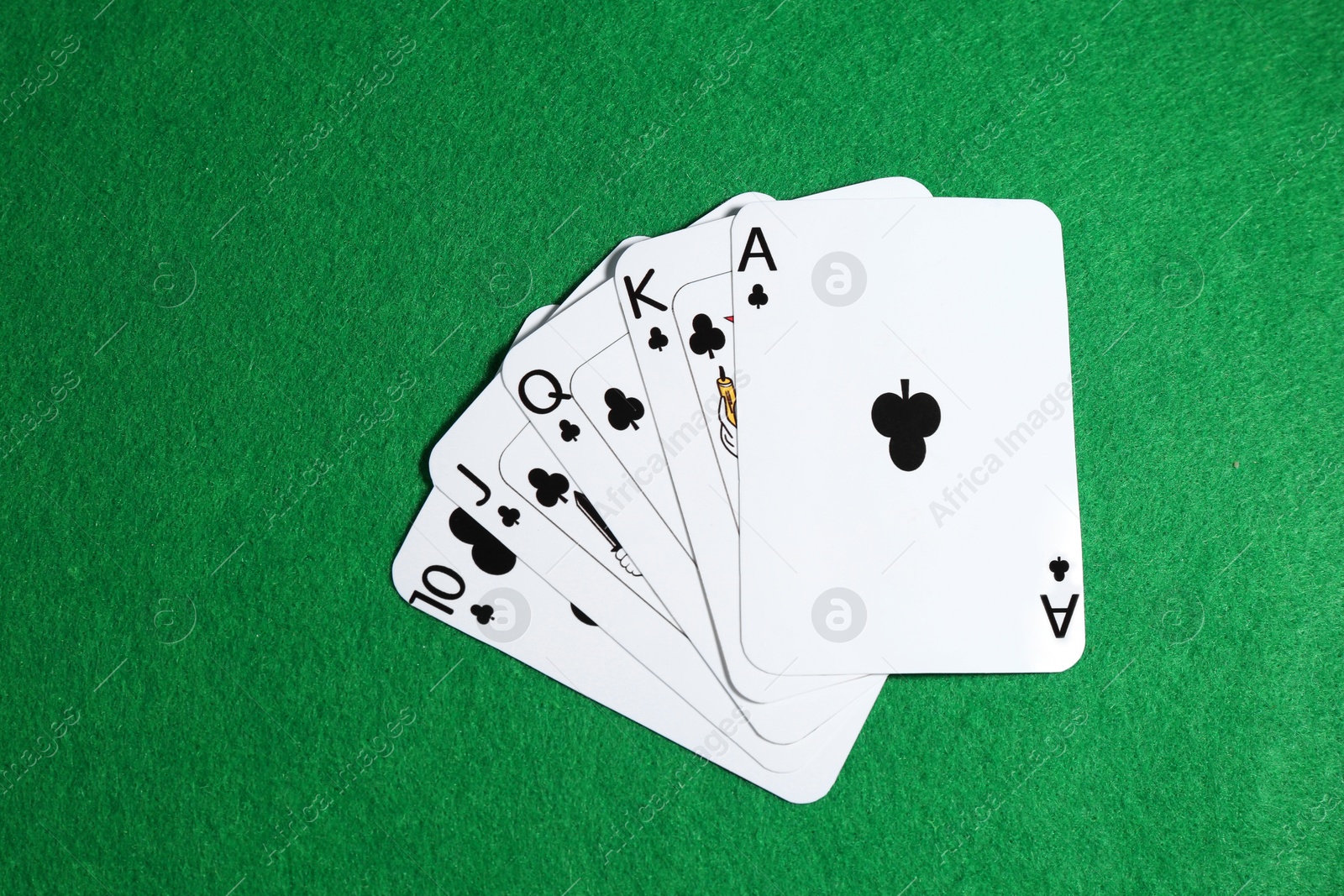 Photo of Poker game. Playing cards on green table, top view