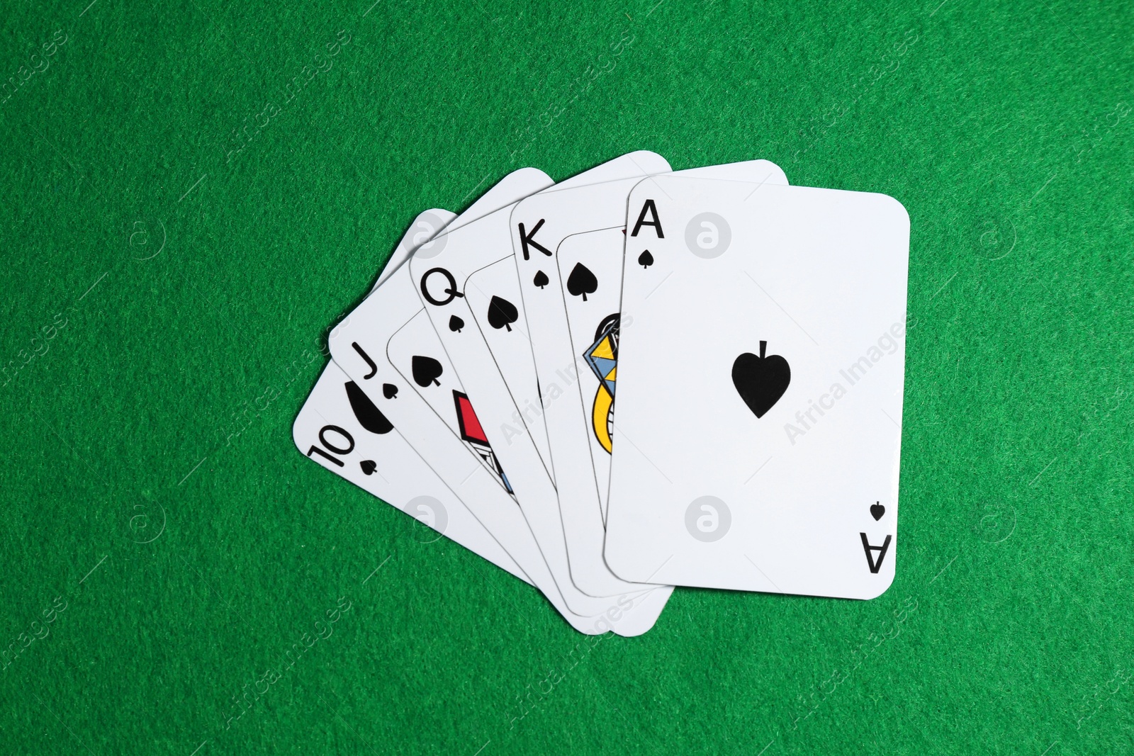 Photo of Poker game. Playing cards on green table, top view