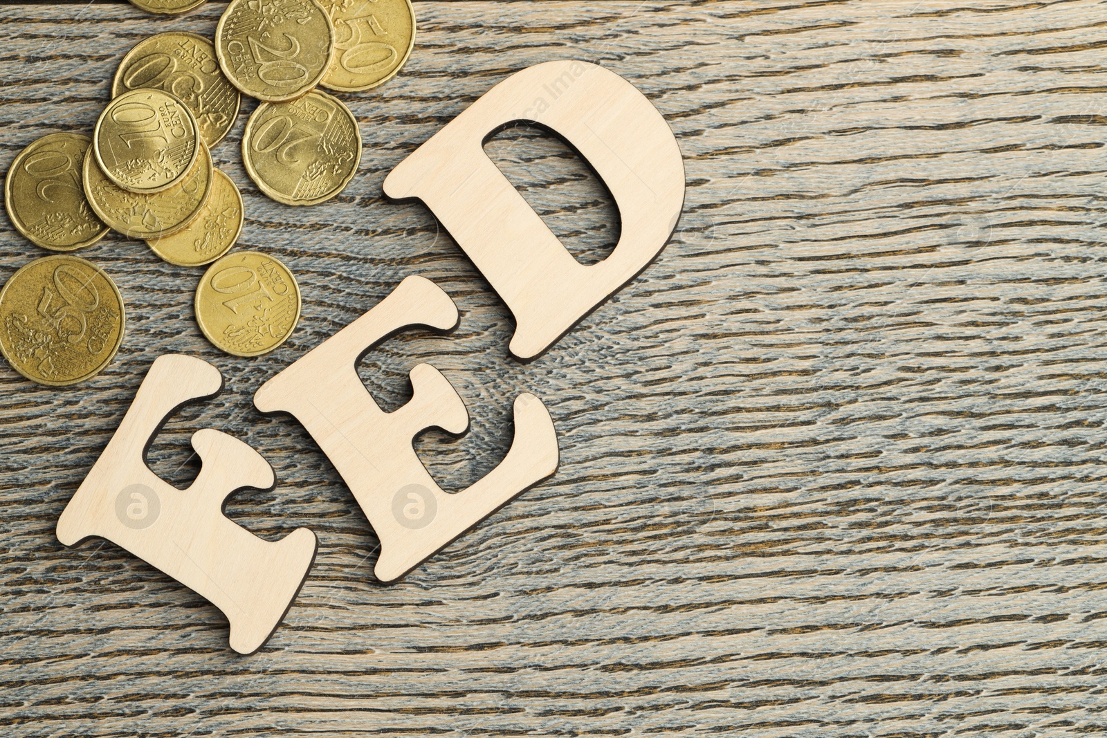 Photo of Word Fed (Federal Reserve System) made with letters and coins on wooden table, flat lay. Space for text