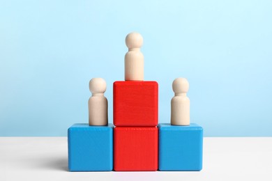 Photo of Winner. Wooden figures on podium against color background