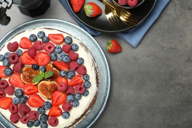 Photo of Delicious chocolate sponge cake with berries served on grey table, top view. Space for text