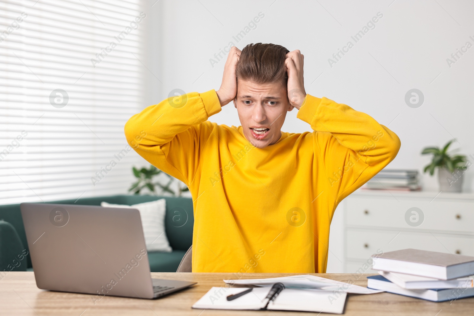 Photo of Tired student having stress before exam at table indoors