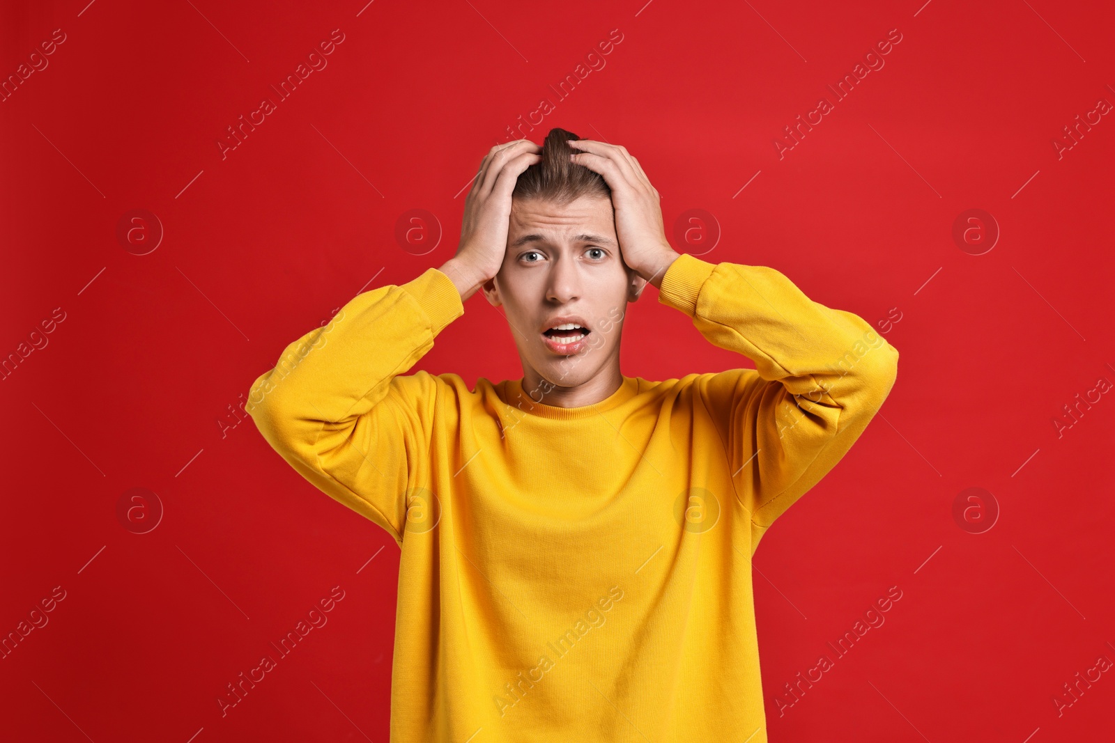 Photo of Emotional student having stress before exam on red background