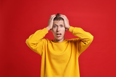 Emotional student having stress before exam on red background